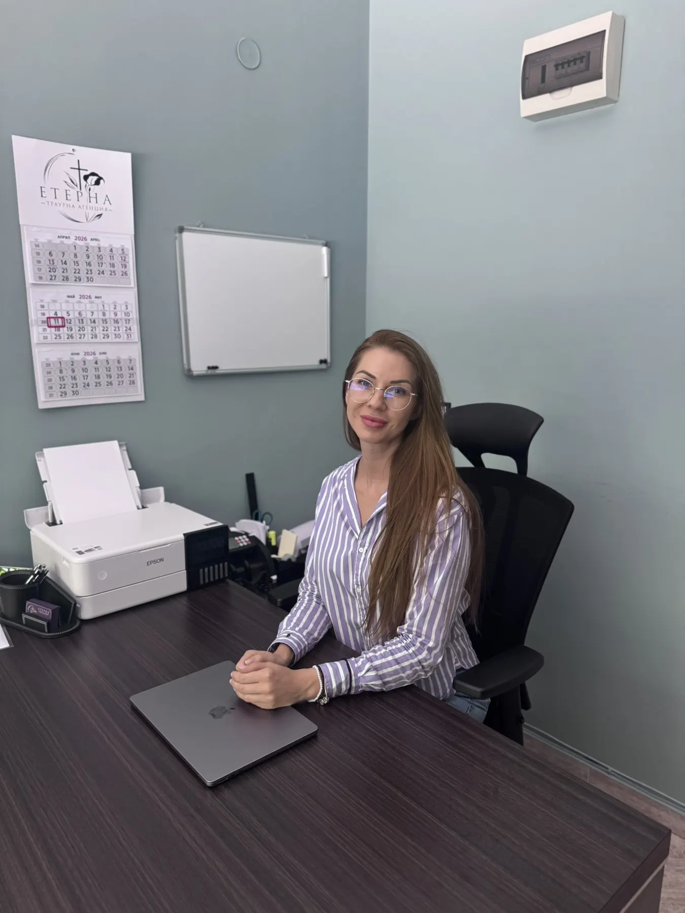 Служителка на траурна агенция „Етерна“ зад бюрото в офиса в София