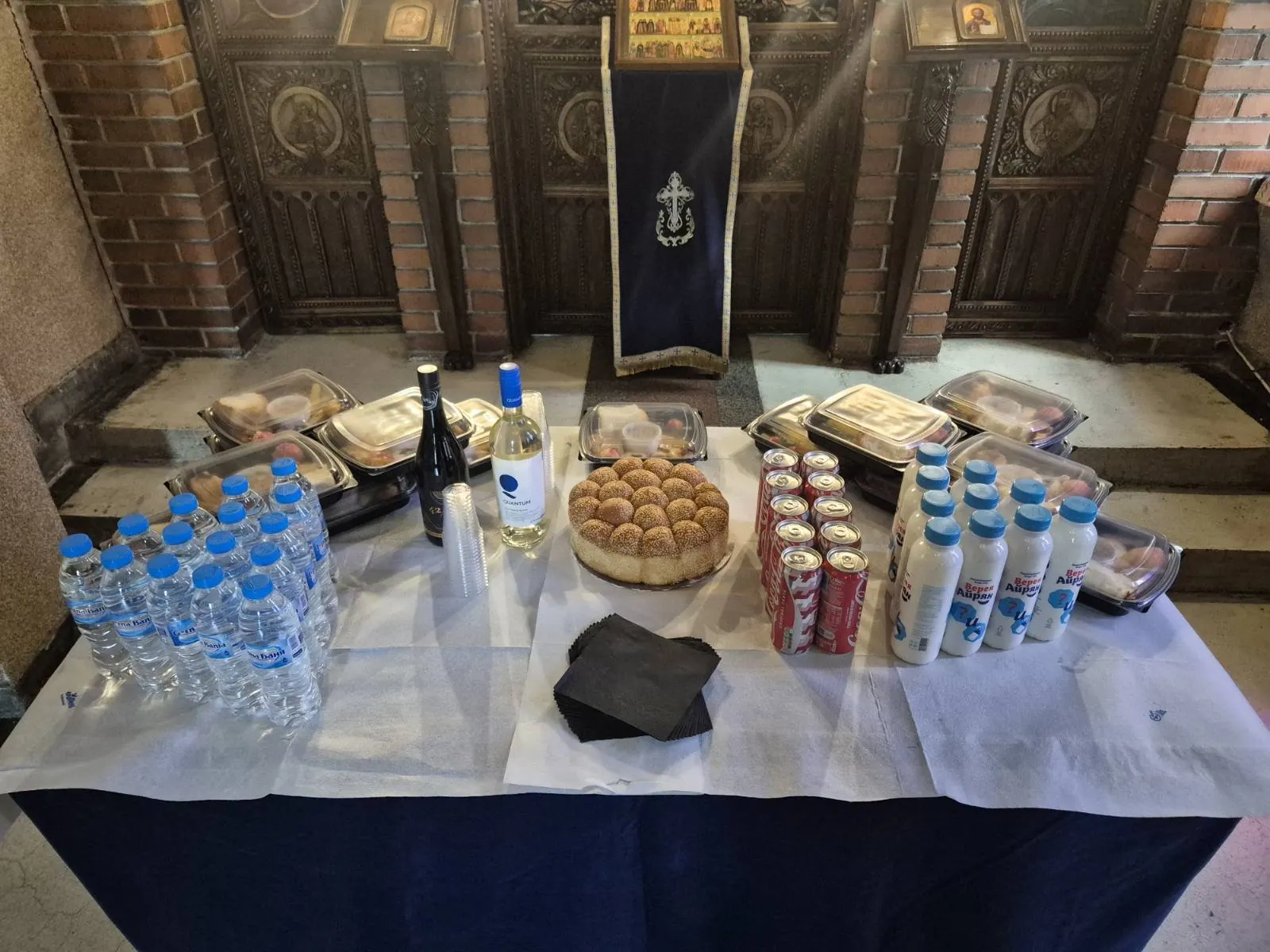 Маса за помен с вода, вино, хляб и напитки пред иконите в църква